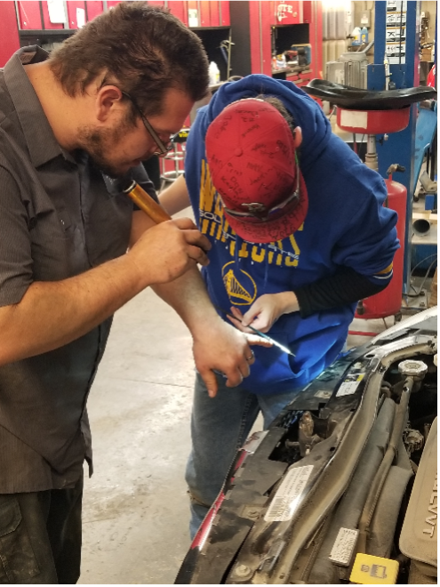 Josh, Project SEARCH intern, learning basic vehicle maintenance with Transportation Services.